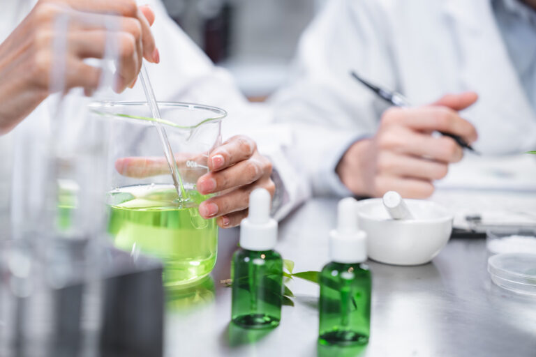 Lab workers analyzing glass beakers of liquid